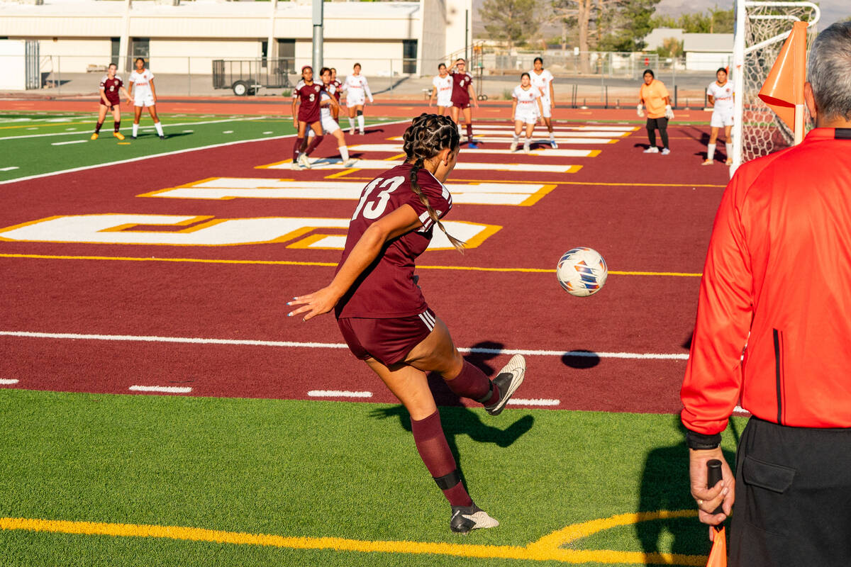 Pahrump Valley (center) Ryleigh Denton (13) attempts a corner kick as the Cowboys and Trojans a ...