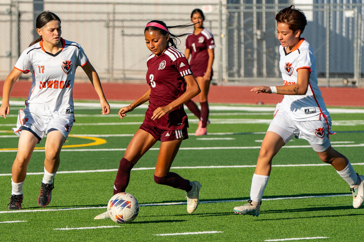 Trojan’s (center) Valery Romero (3) has possession of the ball while two Chaparral Cowbo ...