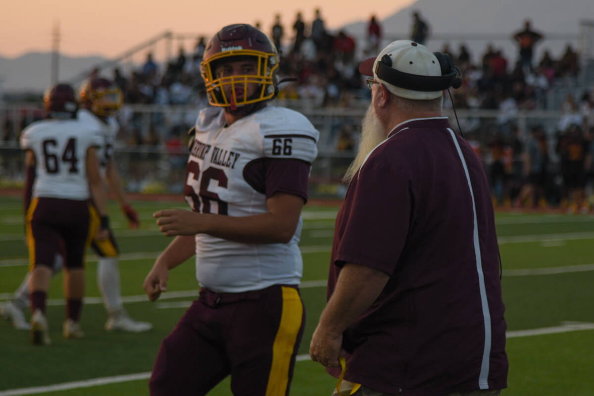 Trojan's coach Walker speaks with Josh Walker (66) in a game against Somerset Academy Losee on ...