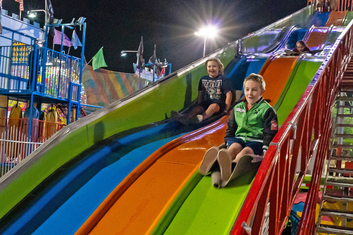 John Clausen/Pahrump Valley Times Sweeping down the giant slide, a couple of Fall Festival atte ...