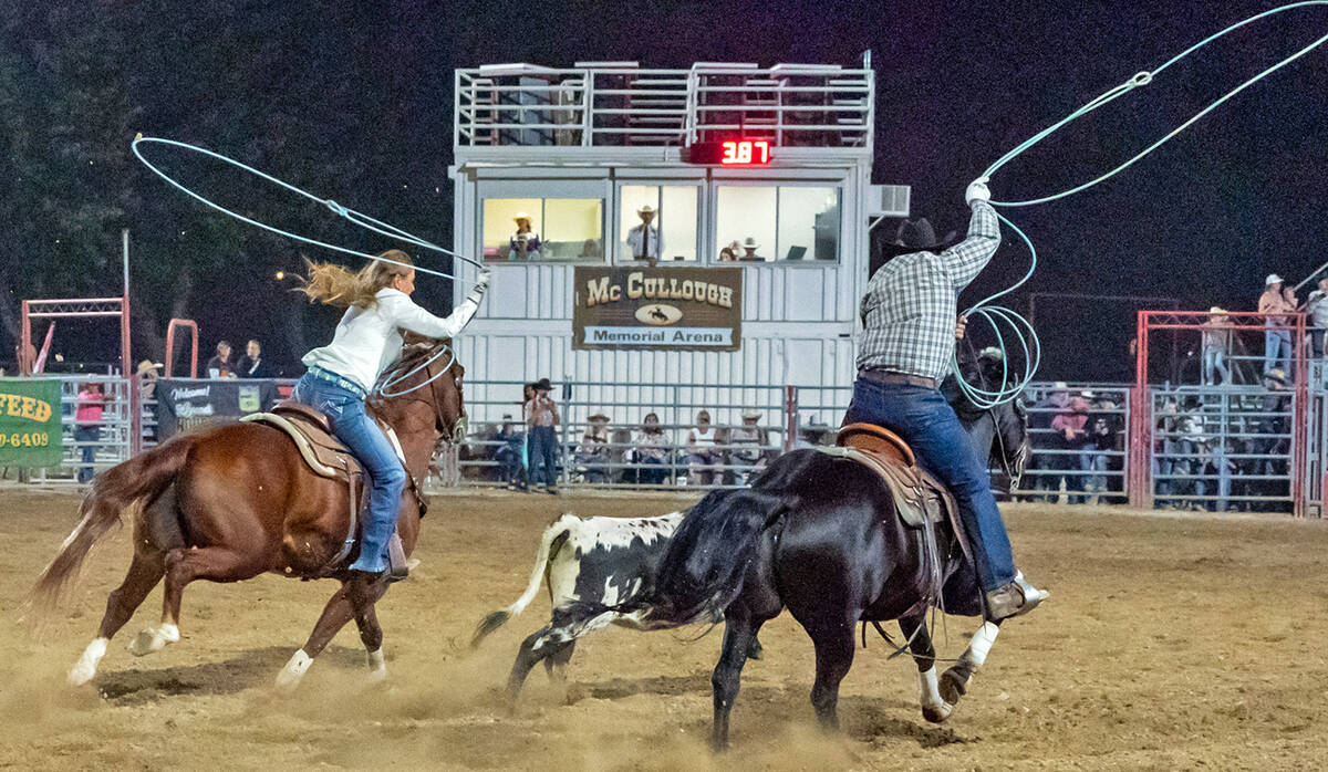 John Clausen/Pahrump Valley Times Working as a team, rodeo competitors strive to rope a calf as ...