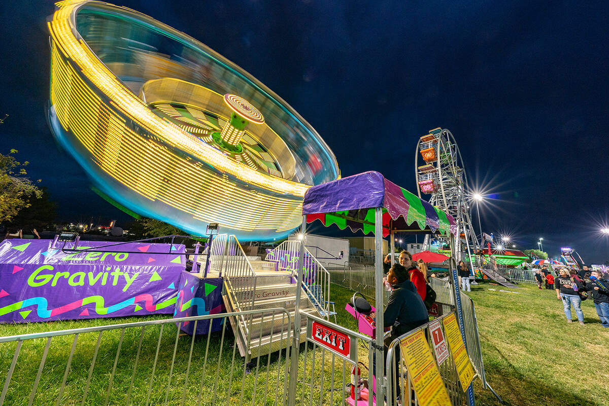 John Clausen/Pahrump Valley Times Defying gravity, a carnival ride lights up the night sky at t ...