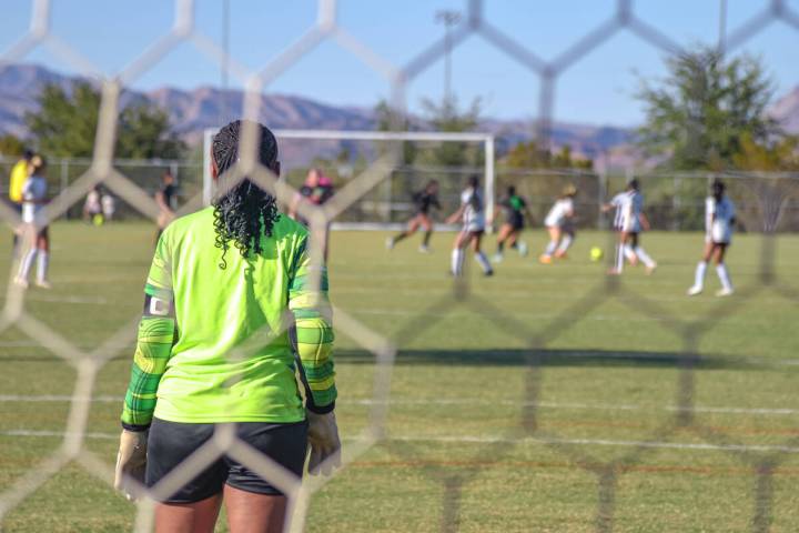 Trojans Madison Williams Mendenhall (12) (center) watches her team battle for the ball against ...