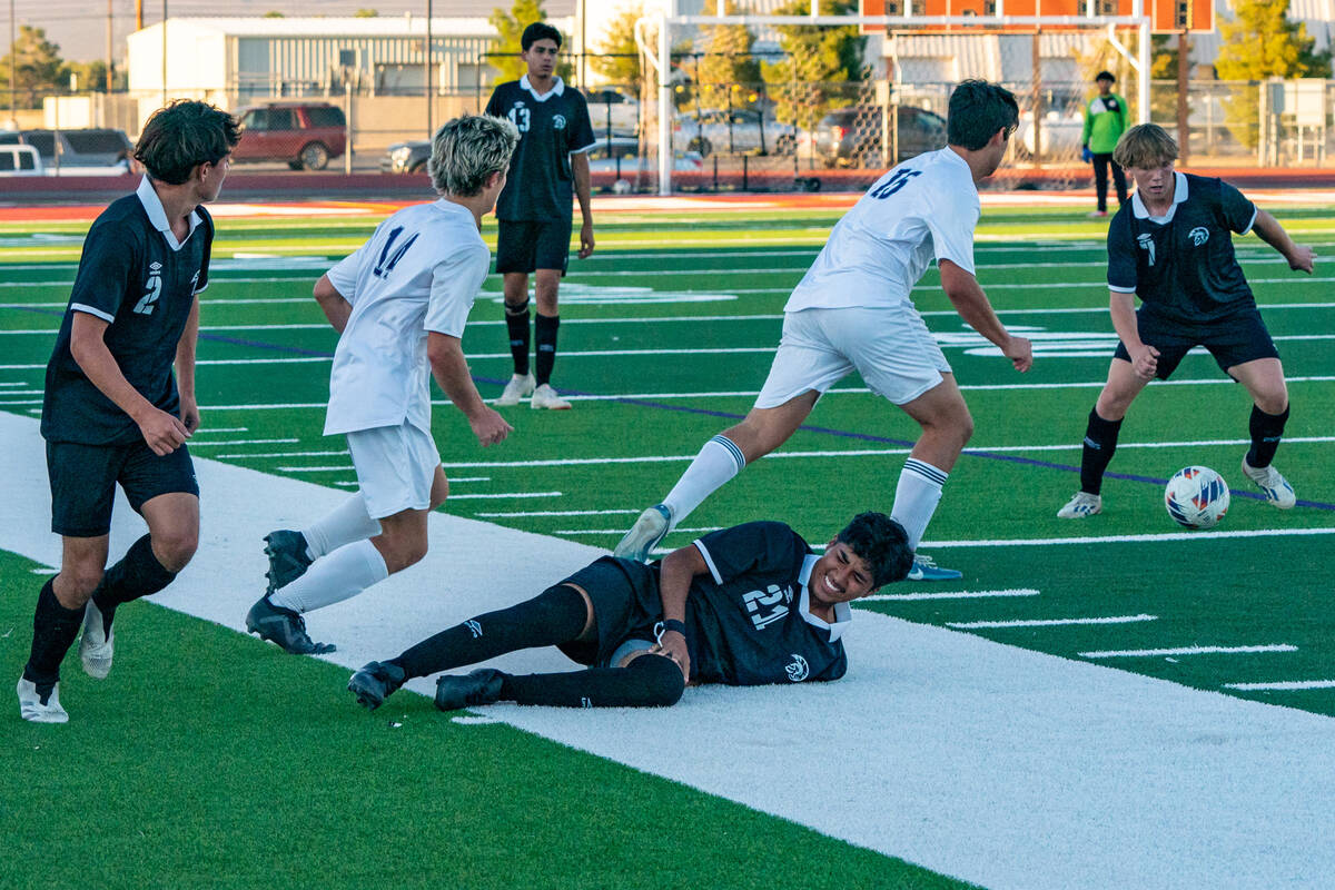 Trojan boys soccer team chases the ball as Fauyan Sida (21) (center) falls to the ground on Tue ...