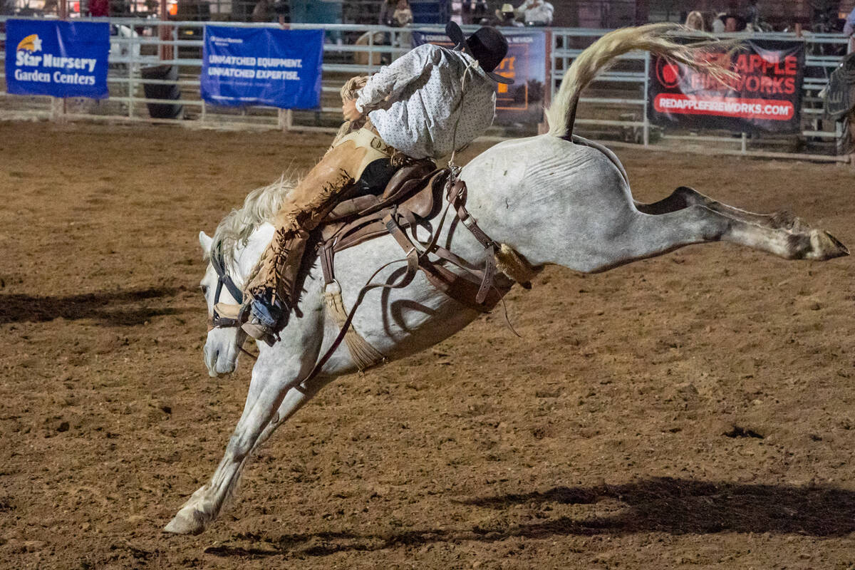 A man braces for impact as a horse attempts throw him off at the Pahrump Fall Festival 2024 rod ...