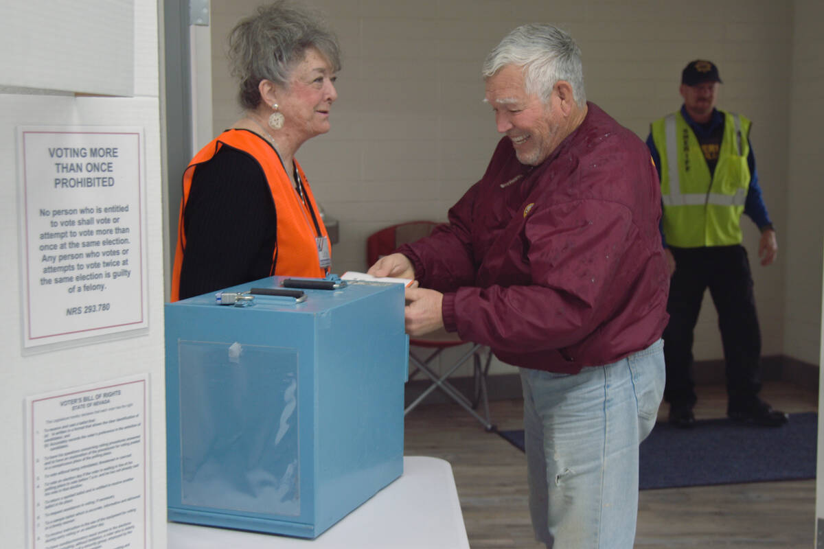 A voter submits his paper ballot in the Bob Ruud Community Center in Pahrump on the primary ele ...