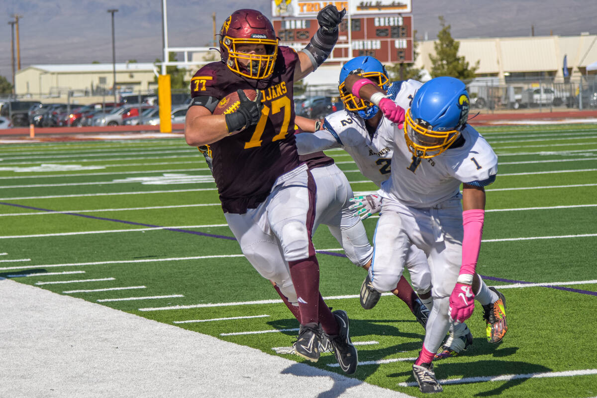 Trojans Hunter Melinger (77) carries the ball before being pushed out by Democracy Prep at the ...