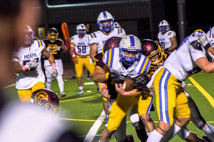 Trojan’s Randal Murray (10) (left) and Austin Alvarez (33) (right) tackle Moapa Valley&# ...