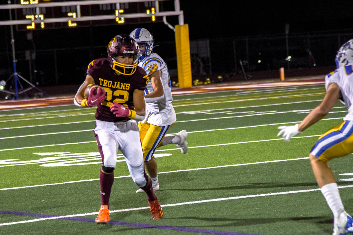 Trojan’s Benjamin De Santiago (22) runs the ball against the Moapa Valley Pirates on Thu ...