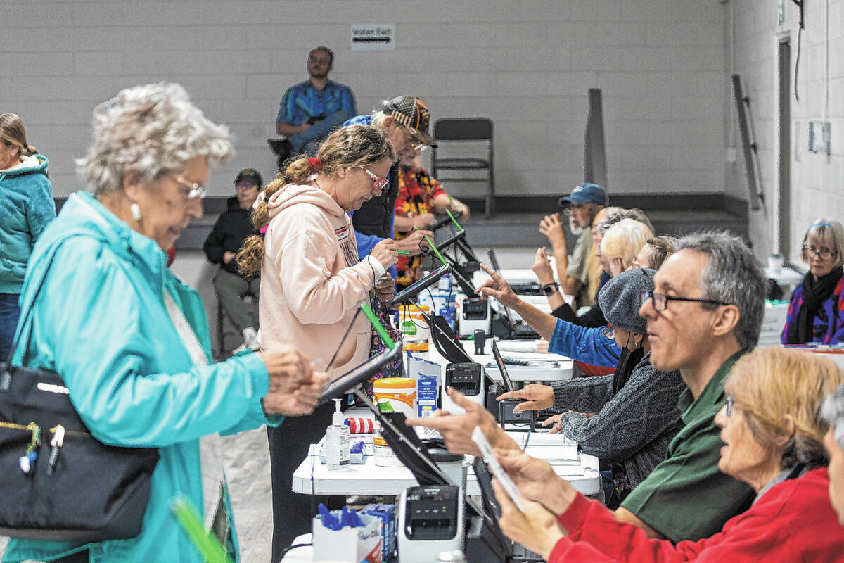 Nye County voters check in with poll workers to cast their ballots on Election Day at Bob Ruud ...