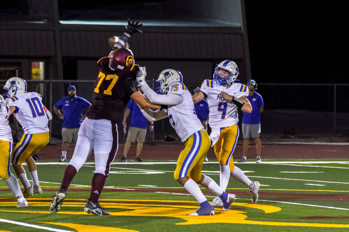 Trojan Hunter Mellinger (77) attempts to block Moapa Valley's throw on Thursday, Oct. 10, in a ...