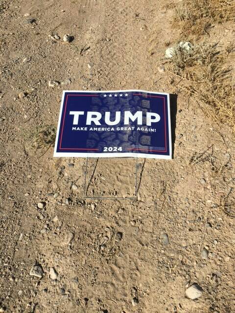 A flattened Trump sign near Bell Vista Avenue and State Route 160 with tire marks lays on the s ...