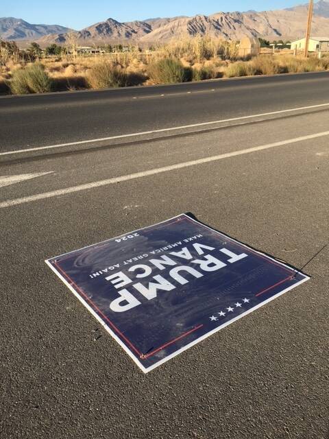 A flattened Trump sign near Manse Road and Clubhouse Drive lays on the road on Wednesday, Oct. ...