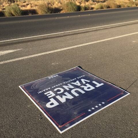 A flattened Trump sign near Manse Road and Clubhouse Drive lays on the road on Wednesday, Oct. ...