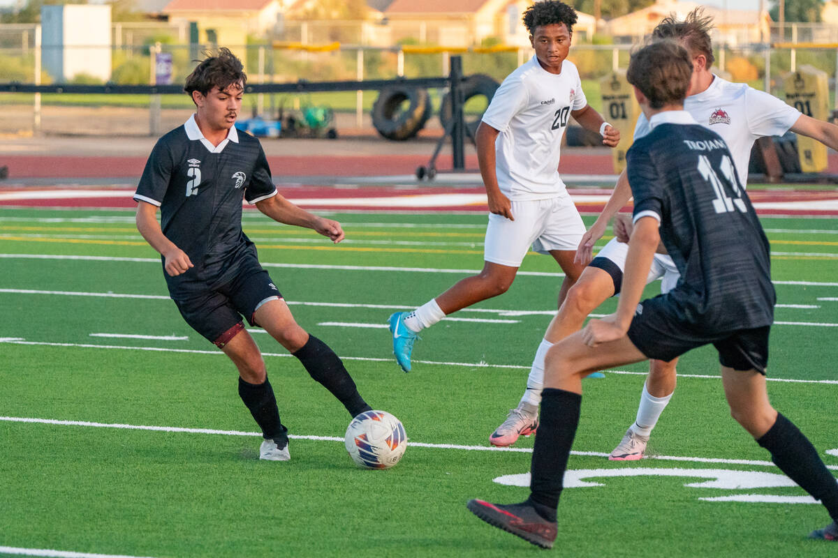 Trojan’s boys soccer Calab Sierra-Hudgens (2) (left) passes to Adrian Leyva (13) (right) ...