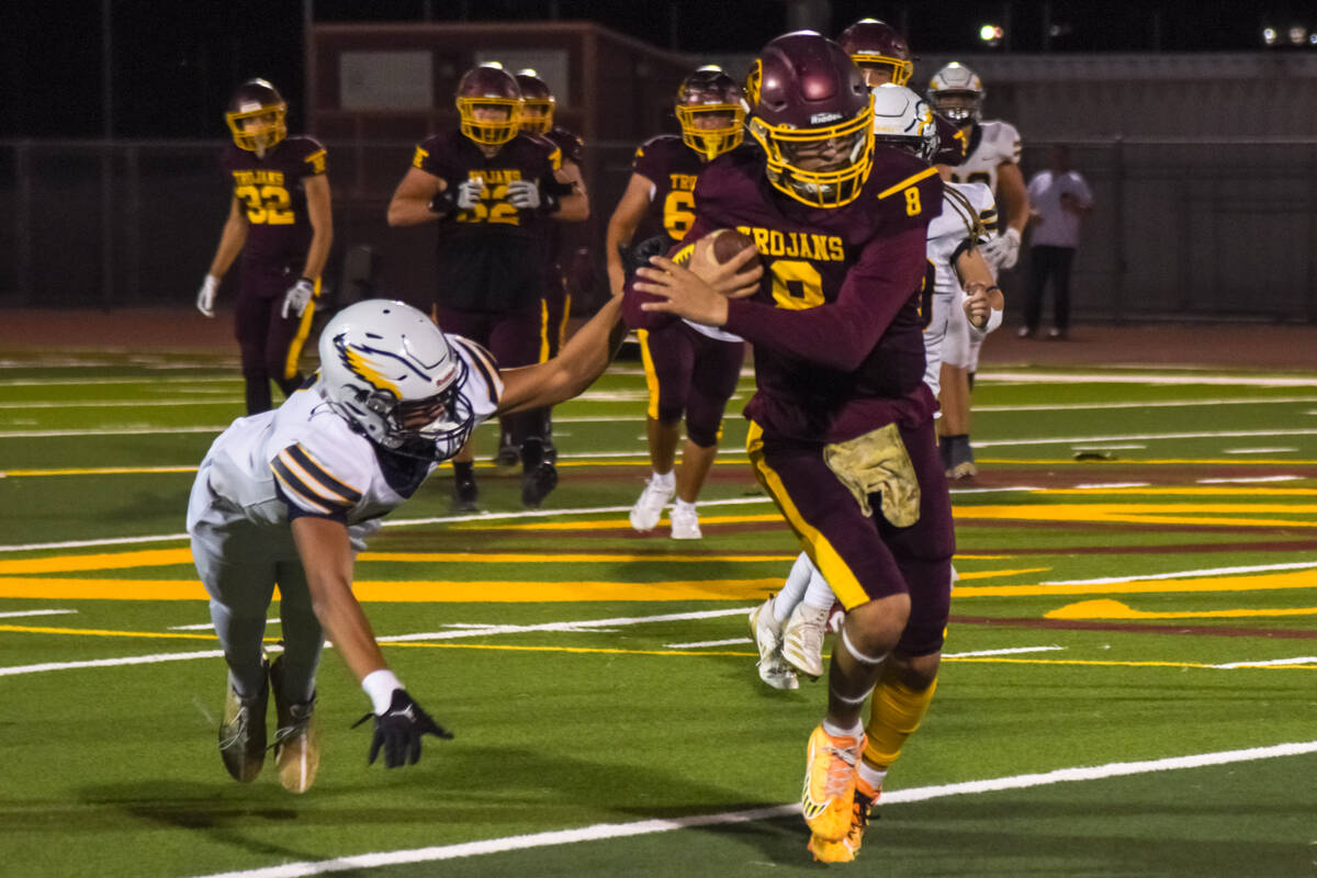 Trojans Kayne Horibe (8) runs the ball as he out runs a Boulder City Eagles player in their las ...