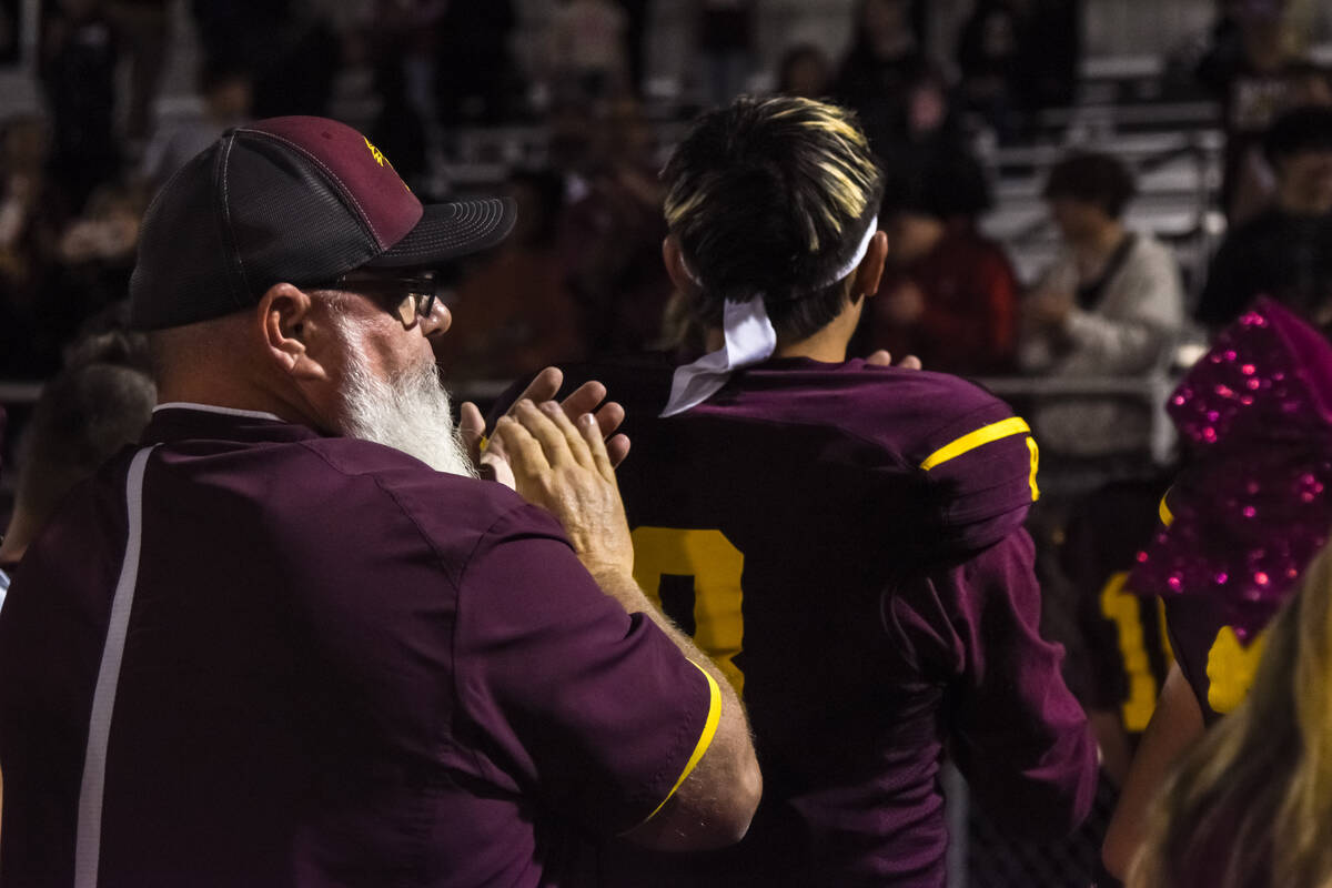 Trojans Head Coach Tom Walker (left) claps and sings along to the fight song with his team afte ...