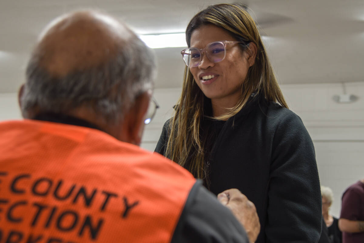 A Nye County voter checks in at the Bob Ruud Community Center to cast her ballot with her daugh ...