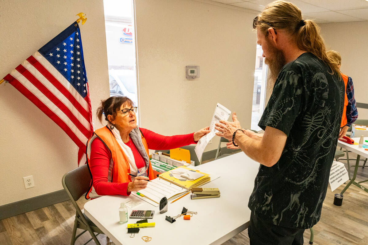 John Clausen/Pahrump Valley Times A Nye County poll worker hands a voter a paper ballot at the ...