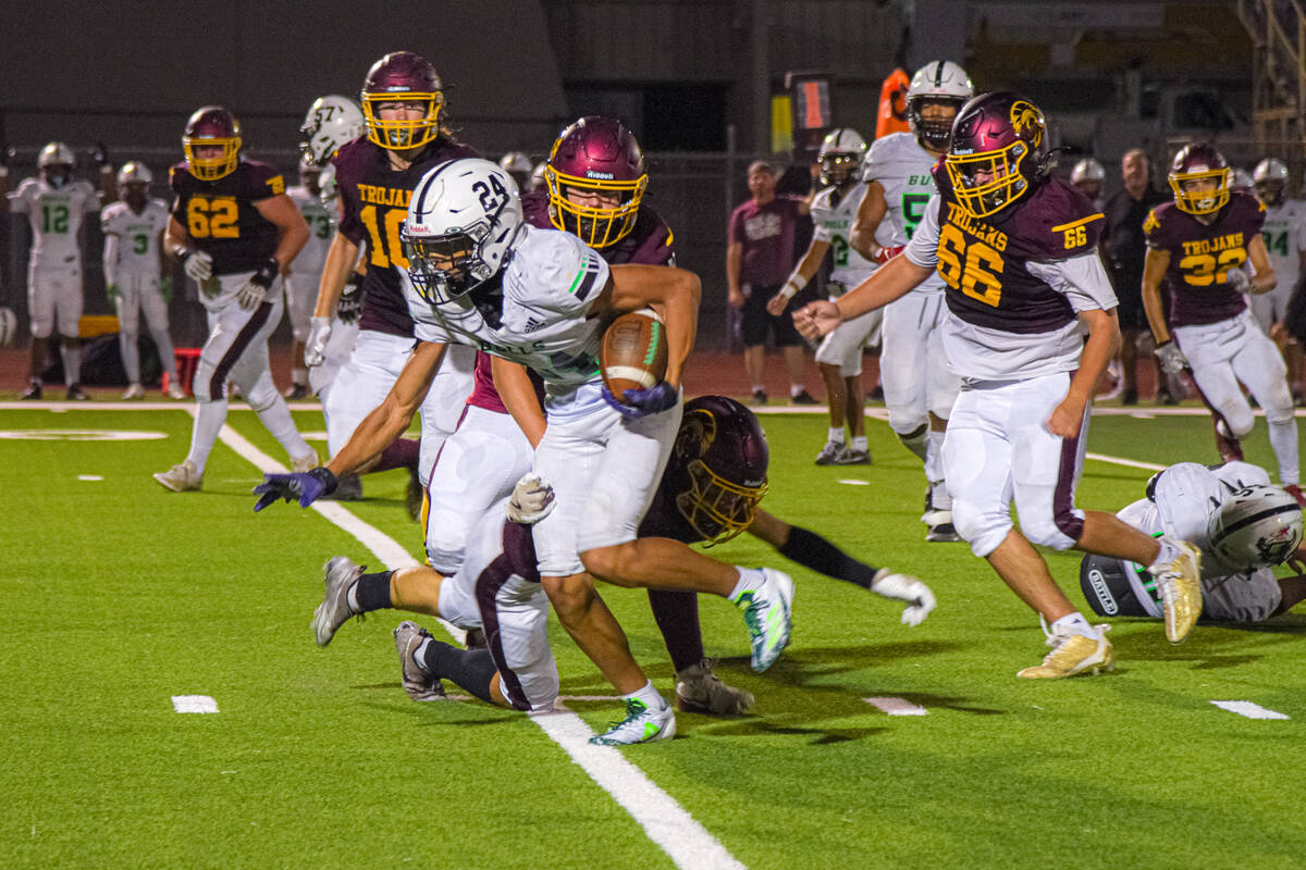 SLAM’s Greg Waters-Cortez (24) is being tackled by Trojan’s defensive players who ...