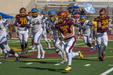 Trojans Carter Nygaard (2) carries the ball against Democracy Prep as Pahrump Valley players ho ...