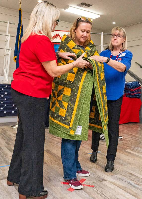 John Clausen/Pahrump Valley Times Nye County Valor Quilters drape one of their unique creations ...