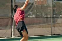 Trojans James Dela Rosa jumps to hit a tennis ball during the NIAA Class 3A Southern League Boy ...