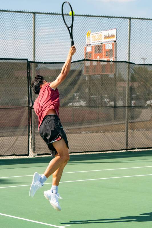 Trojans James Dela Rosa jumps to hit a tennis ball during the NIAA Class 3A Southern League Boy ...