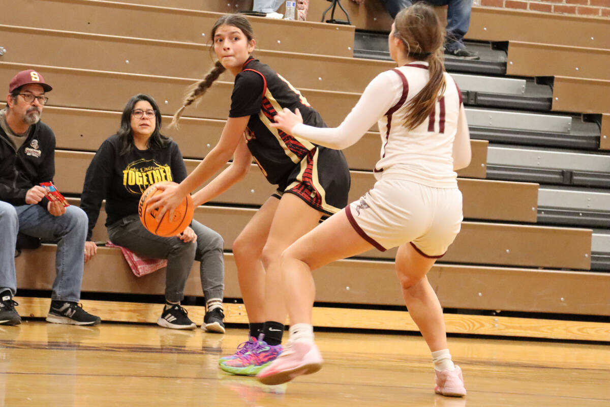 Trojans’ senior Ryleigh Denton (13) is about to pass the ball to her teammates as a Dayt ...