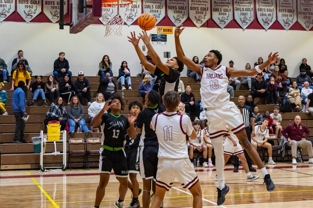 Trojans' Tramaine Burras (13) (right) in mid-air to attempt to block the ball from a SLAM playe ...