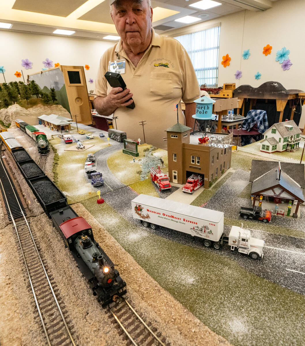 Ray B. Squyres demonstrates how the model train works inside the Pahrump Community Library. The ...