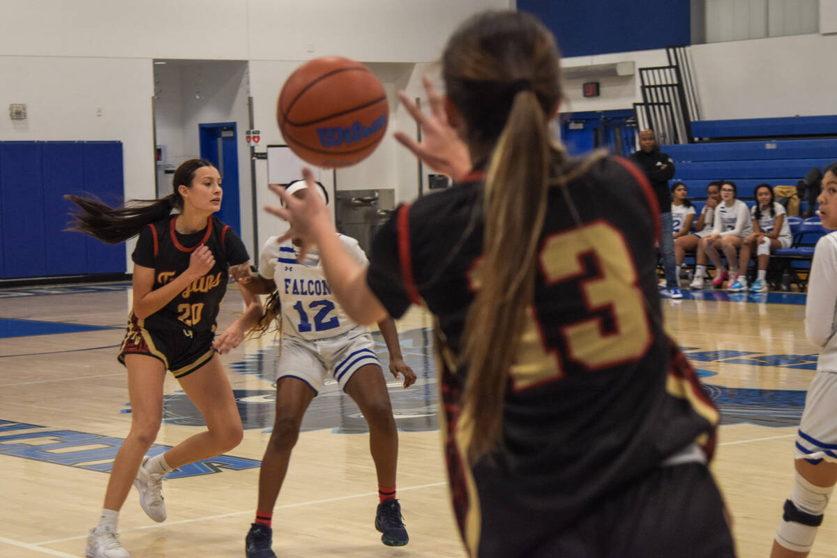 Trojans senior Riley Saldana (20) passes the ball to Ryleigh Denton (13) between the Coral Acad ...