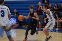 Trojans' junior Keir Sheppard (1) attempts to get past Coral Academy on Friday, Dec. 6, 2024, i ...