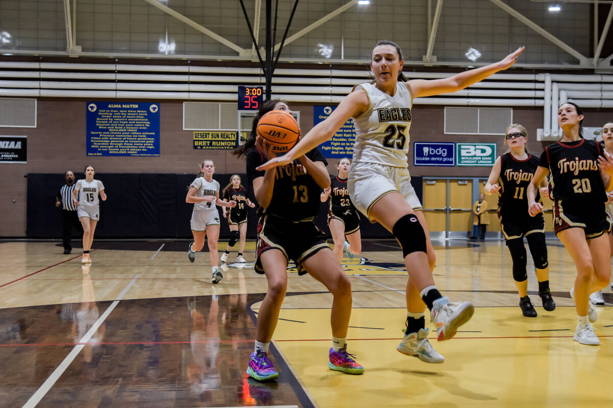 Trojans' senior Ryleigh Denton (13) stops her shot to let Eagles sophomore Mackenzie Martorano ...