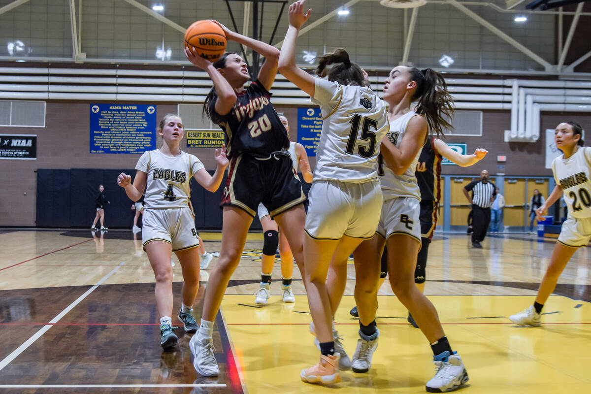 Trojans sophomore Riley Saldana (20) attempts to find an opening to shoot the ball against Boul ...