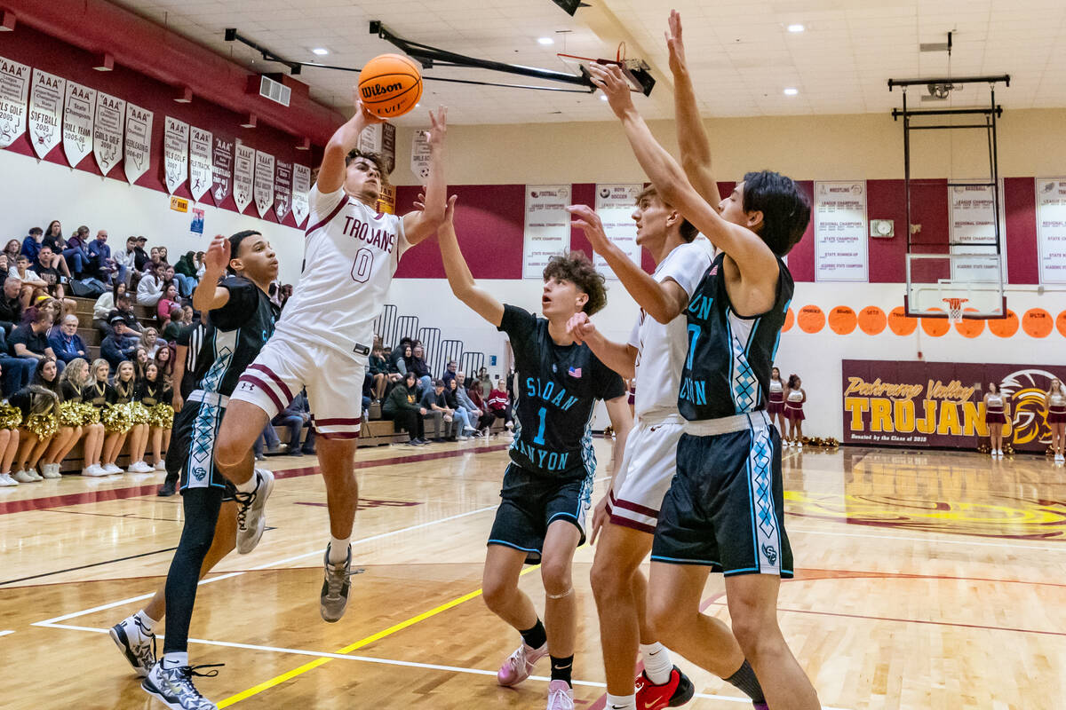 Trojans junior Alejandro Lozano (0) (left) in mid-air attempting to score on Pinecrest Academy ...