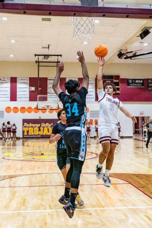 Trojans junior Alejandro Lozano (0) (right) in mid-air attempting to score on Pinecrest Academy ...