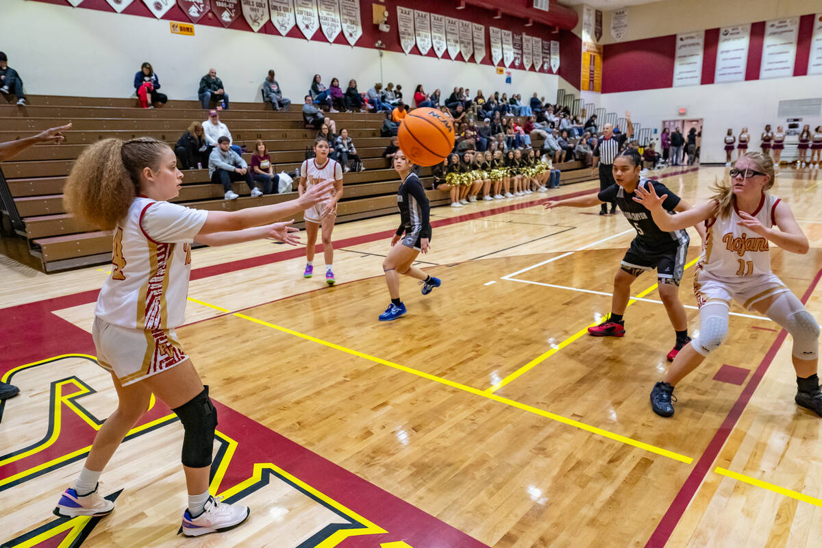 Trojans senior Trinity French (14) passes the ball to junior Savannah Thompson (11) to attempt ...