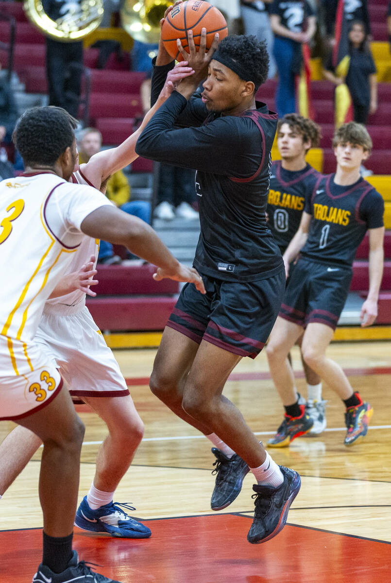 Pahrump Valley forward Tramaine Burras (13) is fouled by Del Sol center William Philips (23) wh ...