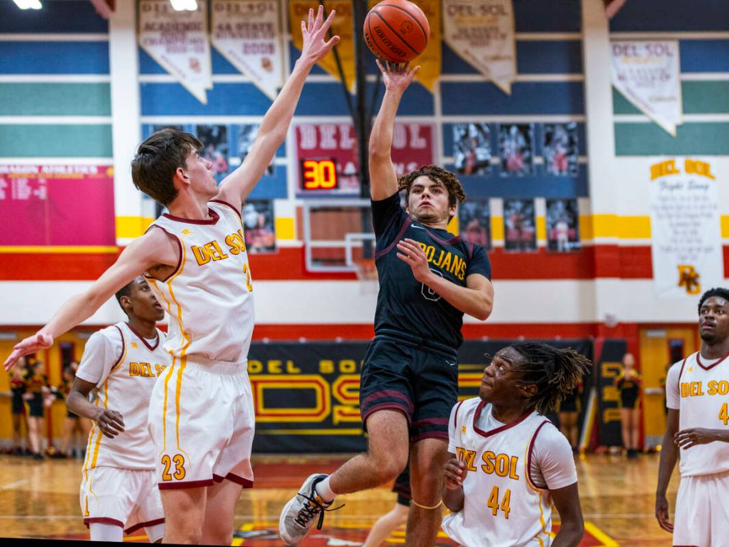 Pahrump Valley guard Alejandro Lozano (0) shoots past Del Sol center William Philips (23) with ...