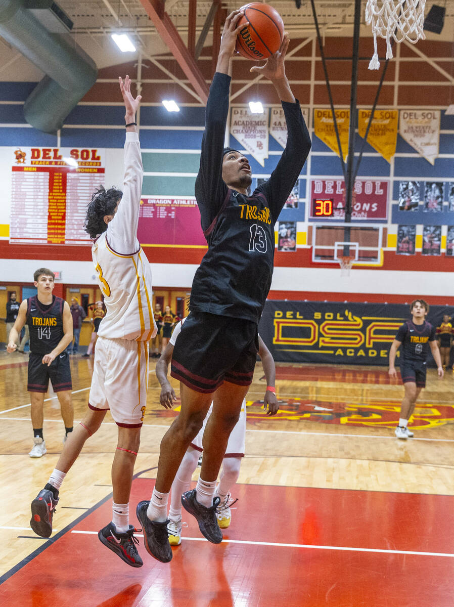 Pahrump Valley forward Tramaine Burras (13) gets past Del Sol guard Raymond Orozco Guevara (3) ...