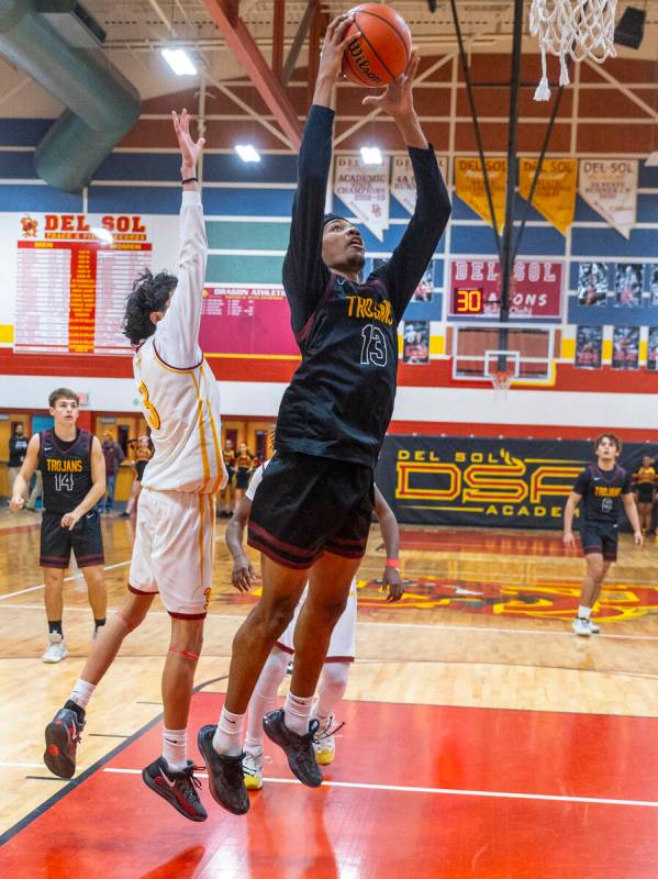 Pahrump Valley forward Tramaine Burras (13) gets past Del Sol guard Raymond Orozco Guevara (3) ...