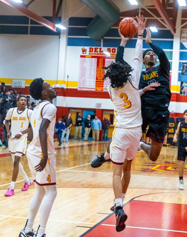 Pahrump Valley forward Tramaine Burras (13) gets over Del Sol guard Raymond Orozco Guevara (3) ...