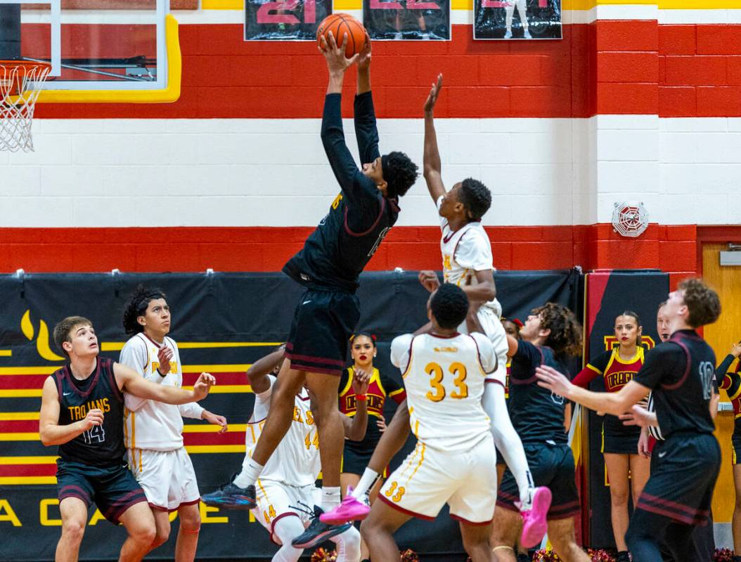 Pahrump Valley forward Tramaine Burras (13) pulls down a rebound in front of Del Sol guard Jaed ...