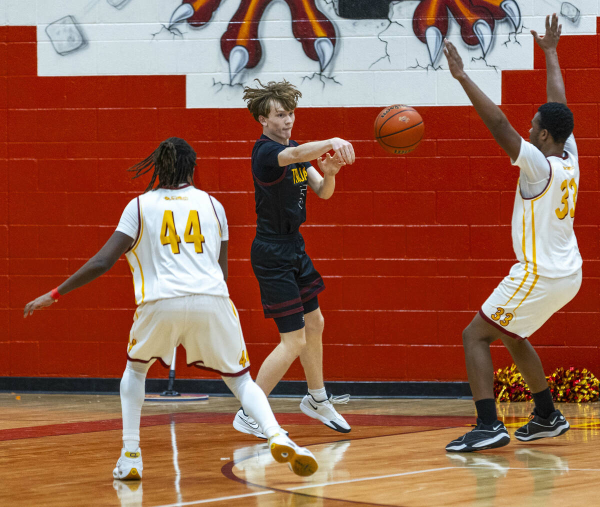 Pahrump Valley guard Jack Toth (5) passes the ball between Del Sol forward James Heath (33) an ...