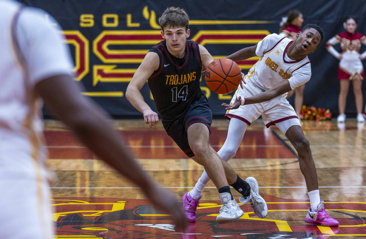 Pahrump Valley guard Joshua Slusher (14) drives the lane past Del Sol guard Jaeden Alexander (1 ...