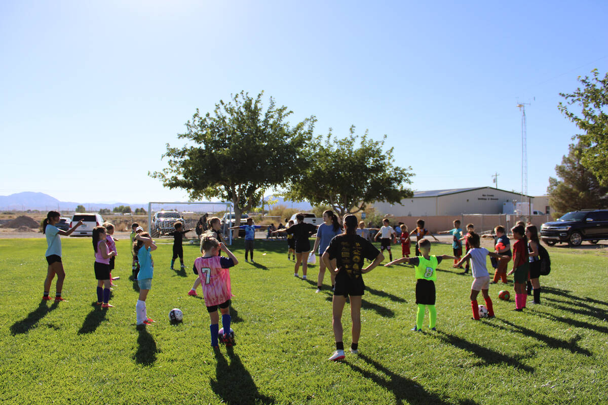 Age groups seven to nine-years-old stretch out with a couple varsity players from the Pahrump V ...