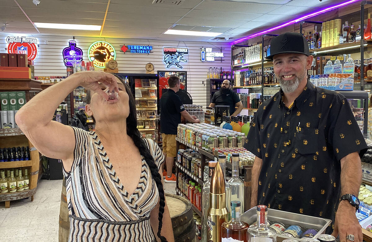 Shooting back a sample of a spicy dill pickle flavored vodka, a local resident enjoys the free ...