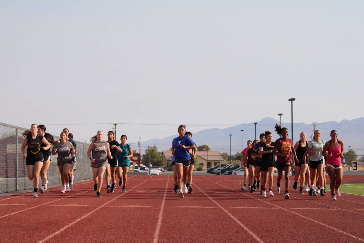 The 2025 Pahrump Valley Girls Soccer team prepares to run a full required mile on the track to ...