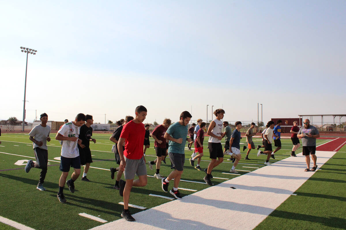 Members trying out for the Pahrump Valley High School soccer program warm up with high knee dri ...